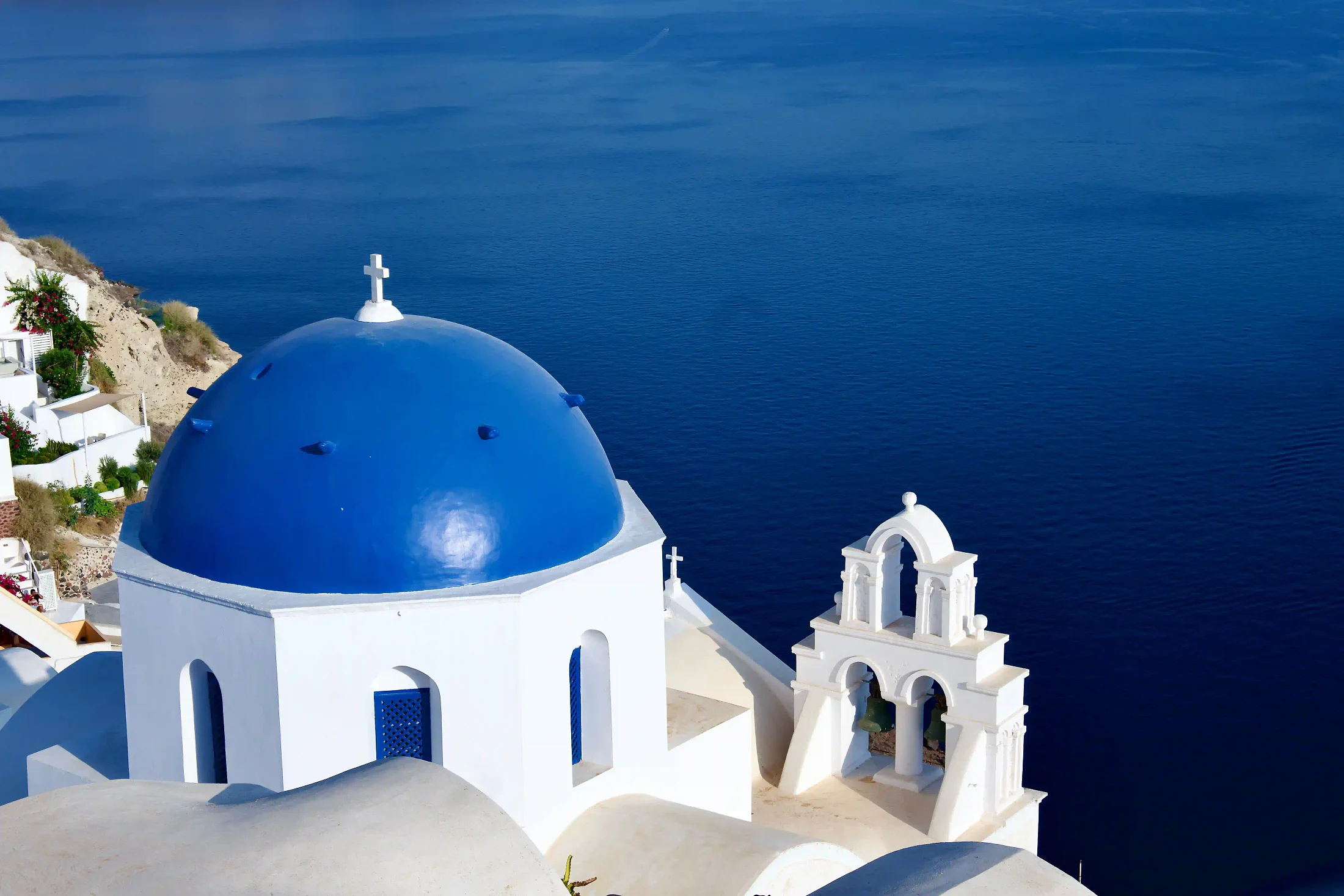 Blue-domed church over the Aegean Sea in Santorini, Greece