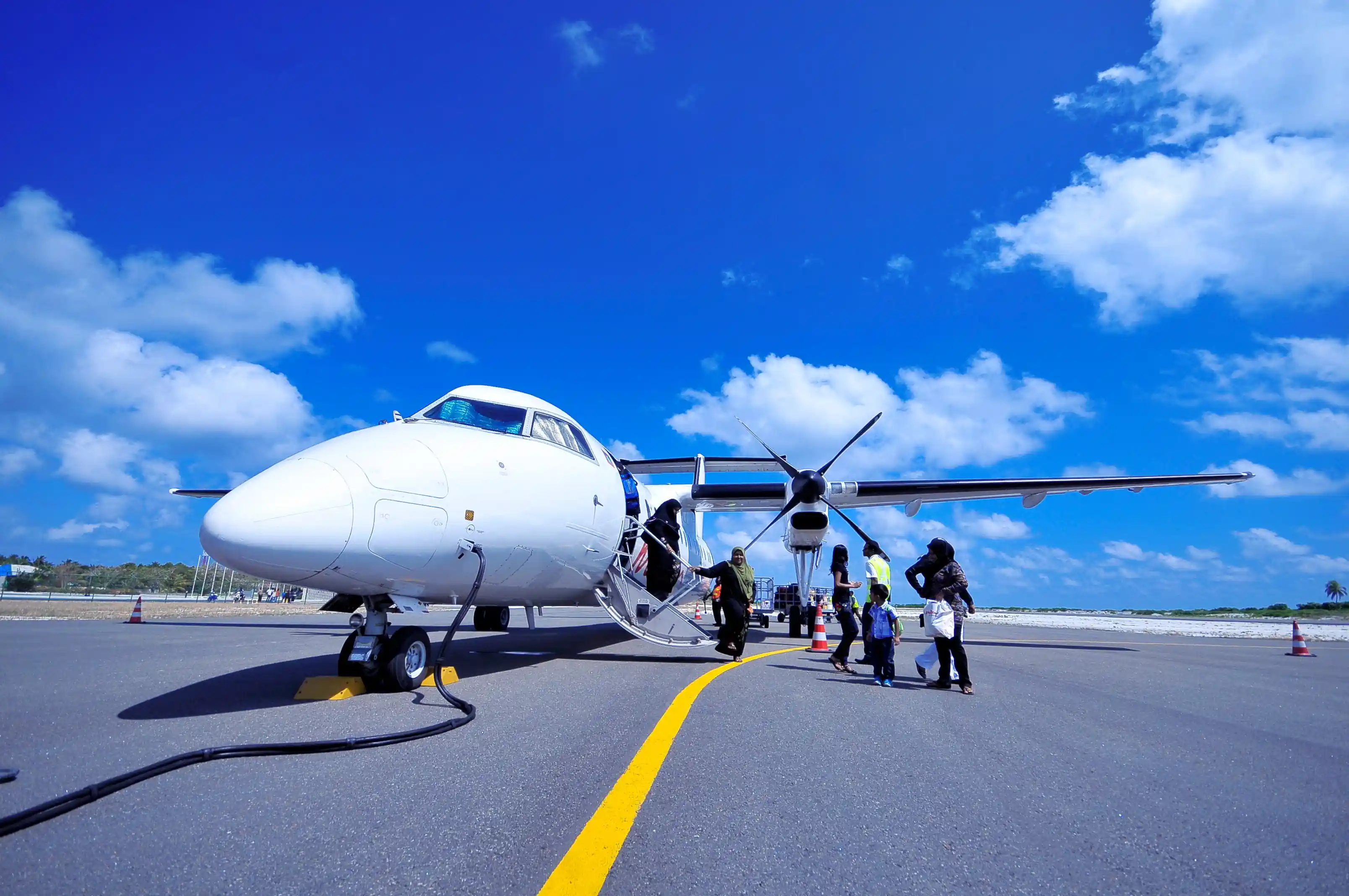 Passengers boarding a turboprop on a Pacific island ramp