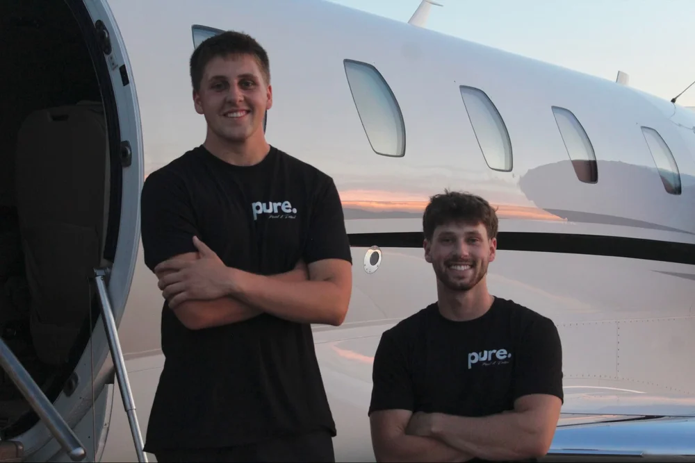 Landon Childers and Wyatt Santone-Engledow, co-owners, beside a business jet